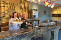 Julia Wittreck und Anja Rodenbeck (rechts) stehen hinter der Theke im Emsbräustübchen. Julia Wittreck hält ein Tablett mit Sektgläsern in Händen, Anja Rodenbeck zapft ein Bier.